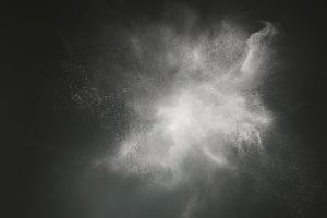 Abstract design of white powder cloud against dark background