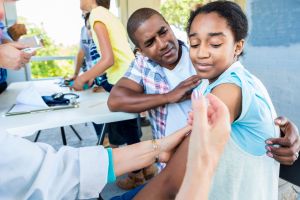 Girl receives flu shot at outdoor free clinic