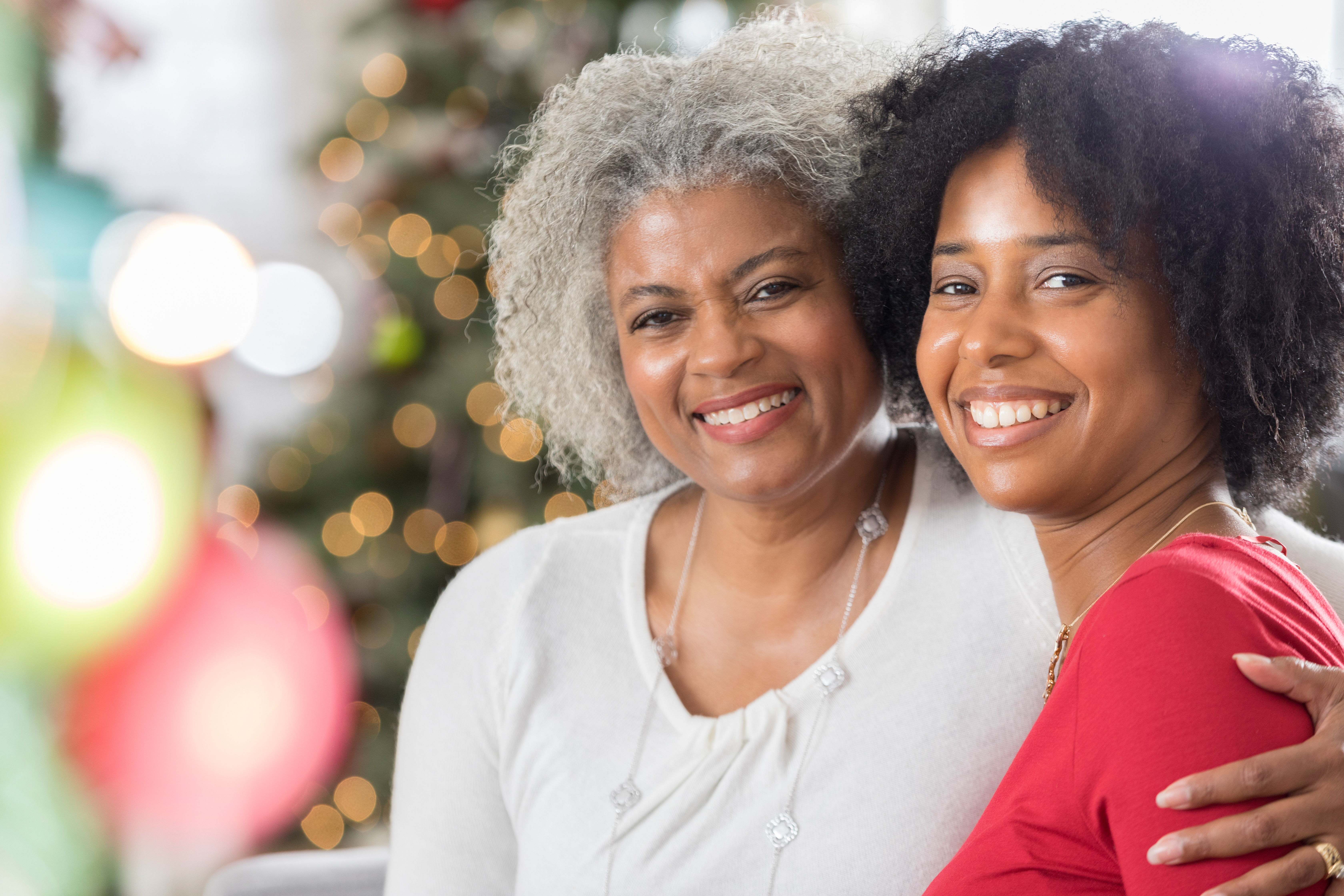 Cheerful senior woman with her adult daughter at Christmastime
