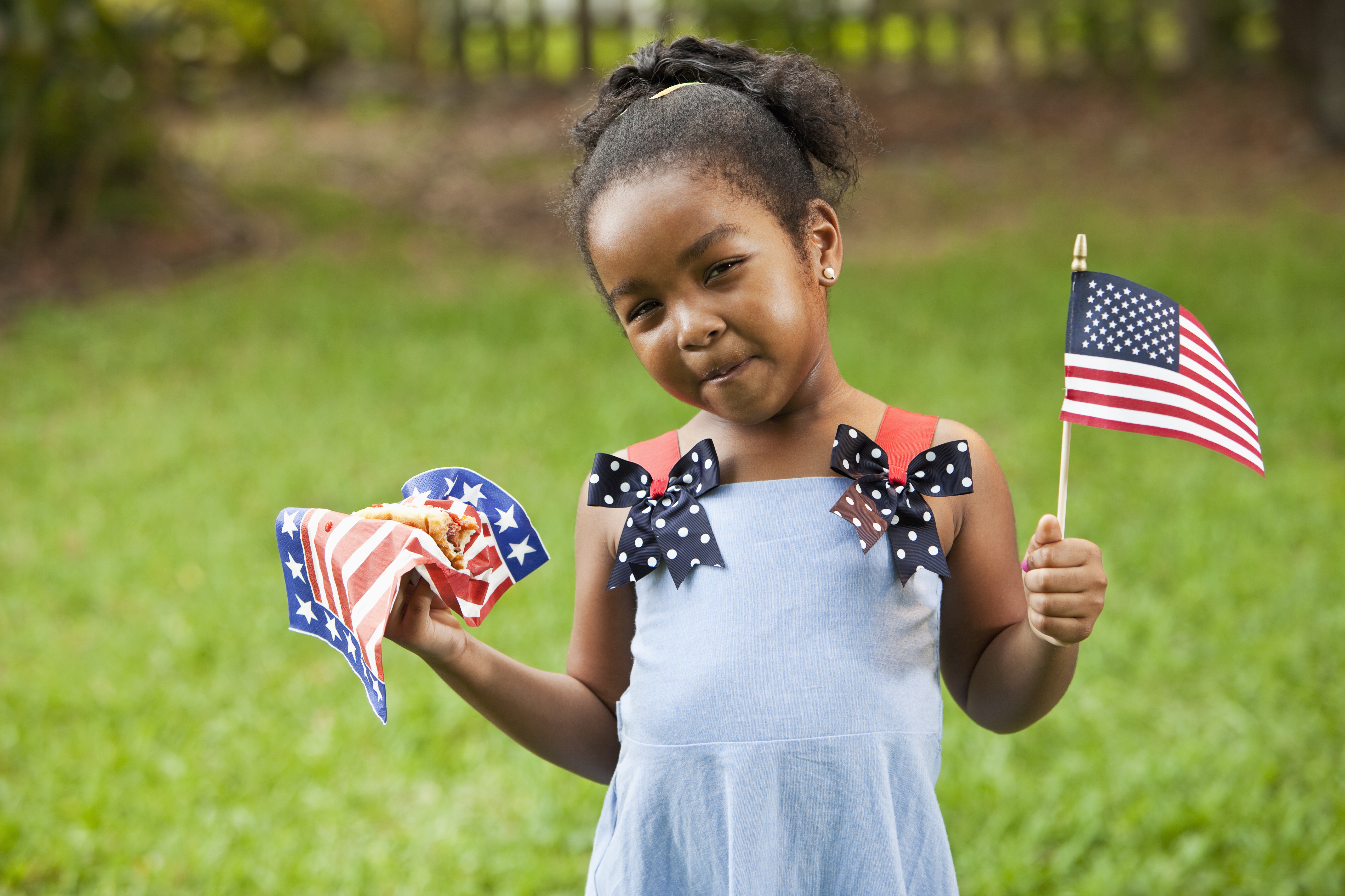 Little girl with American flag and hotdog