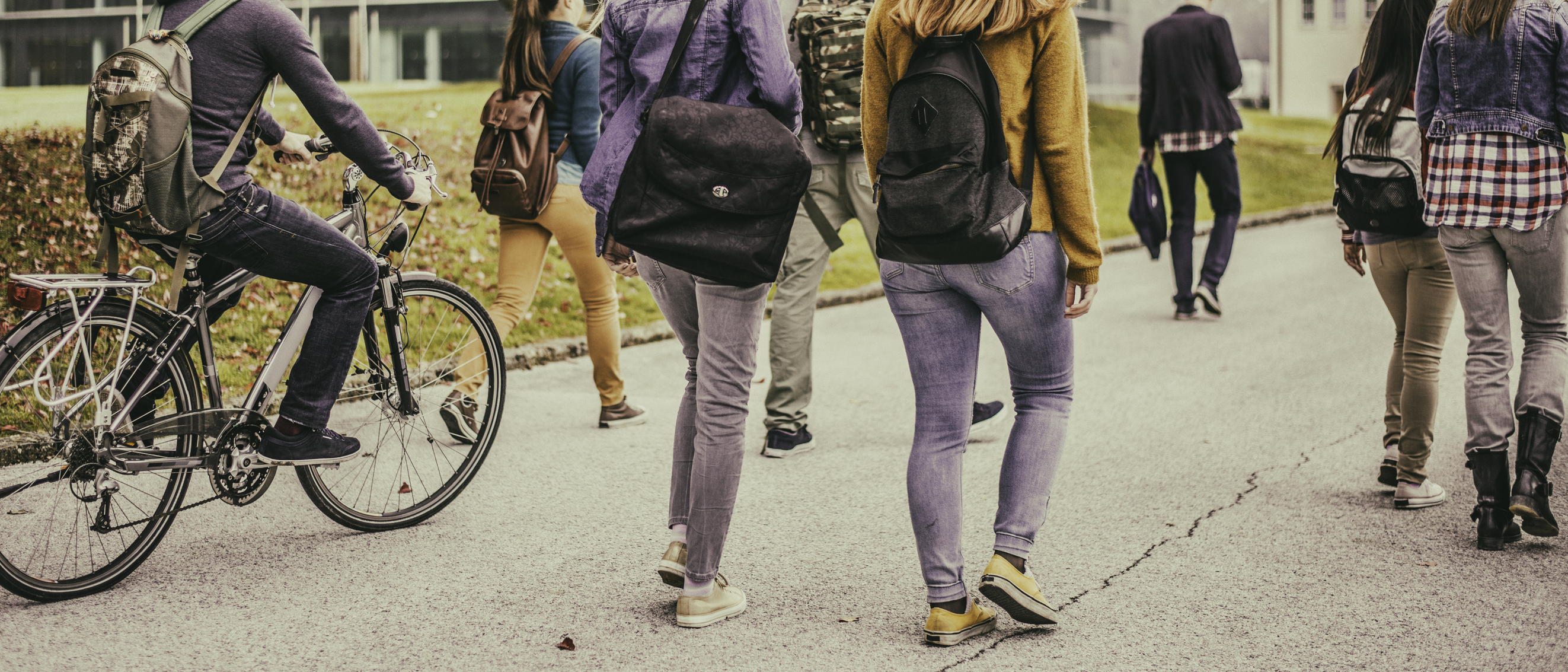 Group of unrecognizable sudents walking through the park