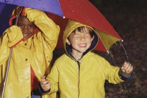 Boys playing in rain under umbrella