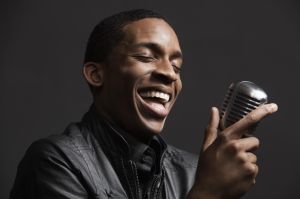 African American man singing into microphone