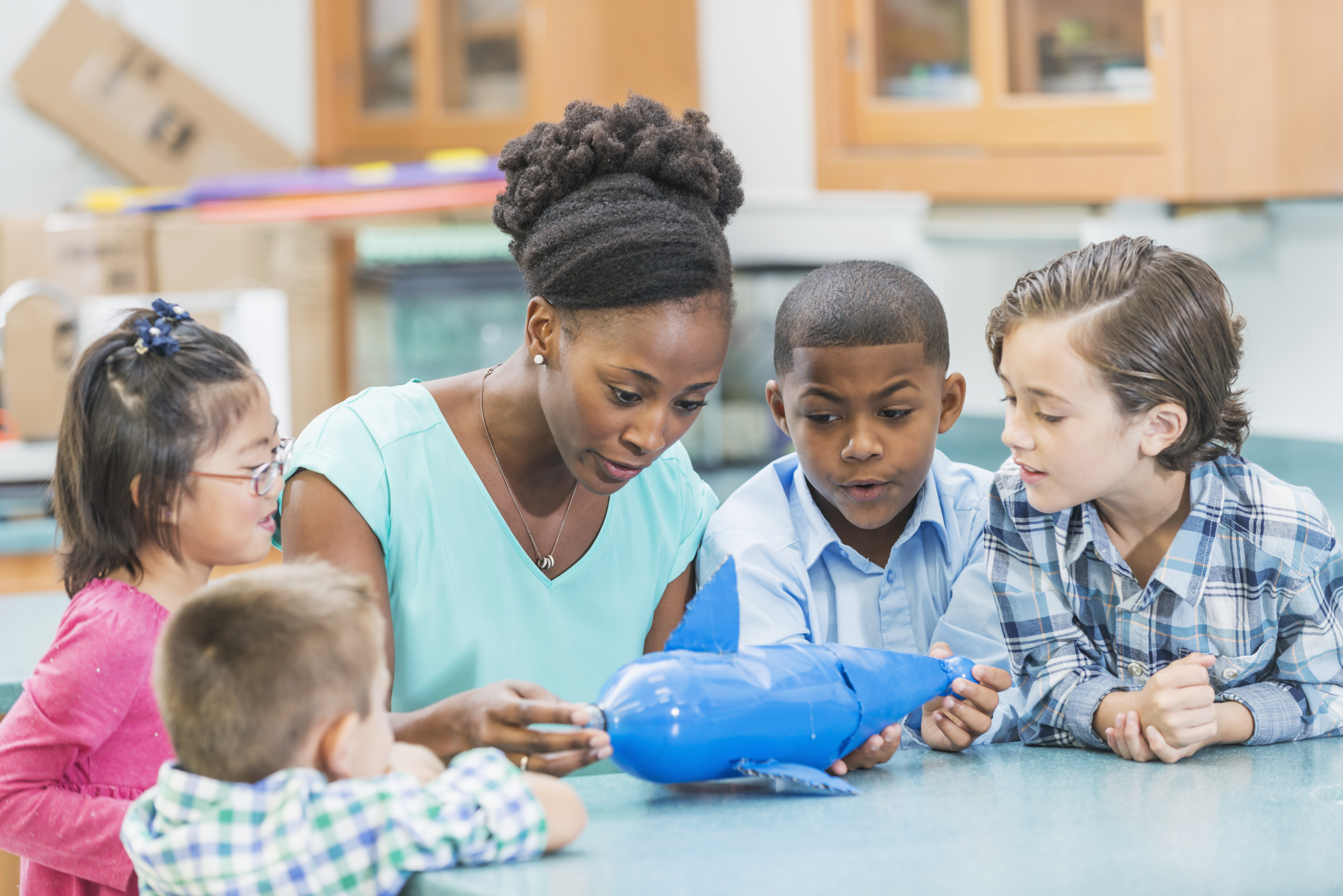 African American science teacher and elementary students