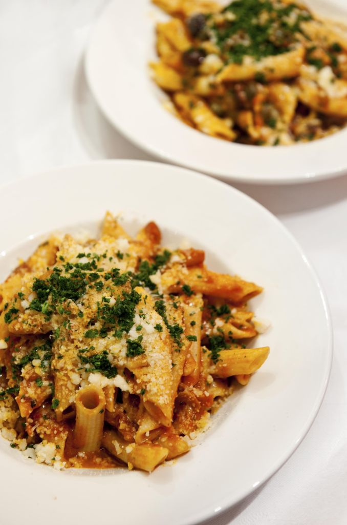 Penne Matriciana Italian Pasta on a plate in restaurant with Parmesan Cheese and Parsley.