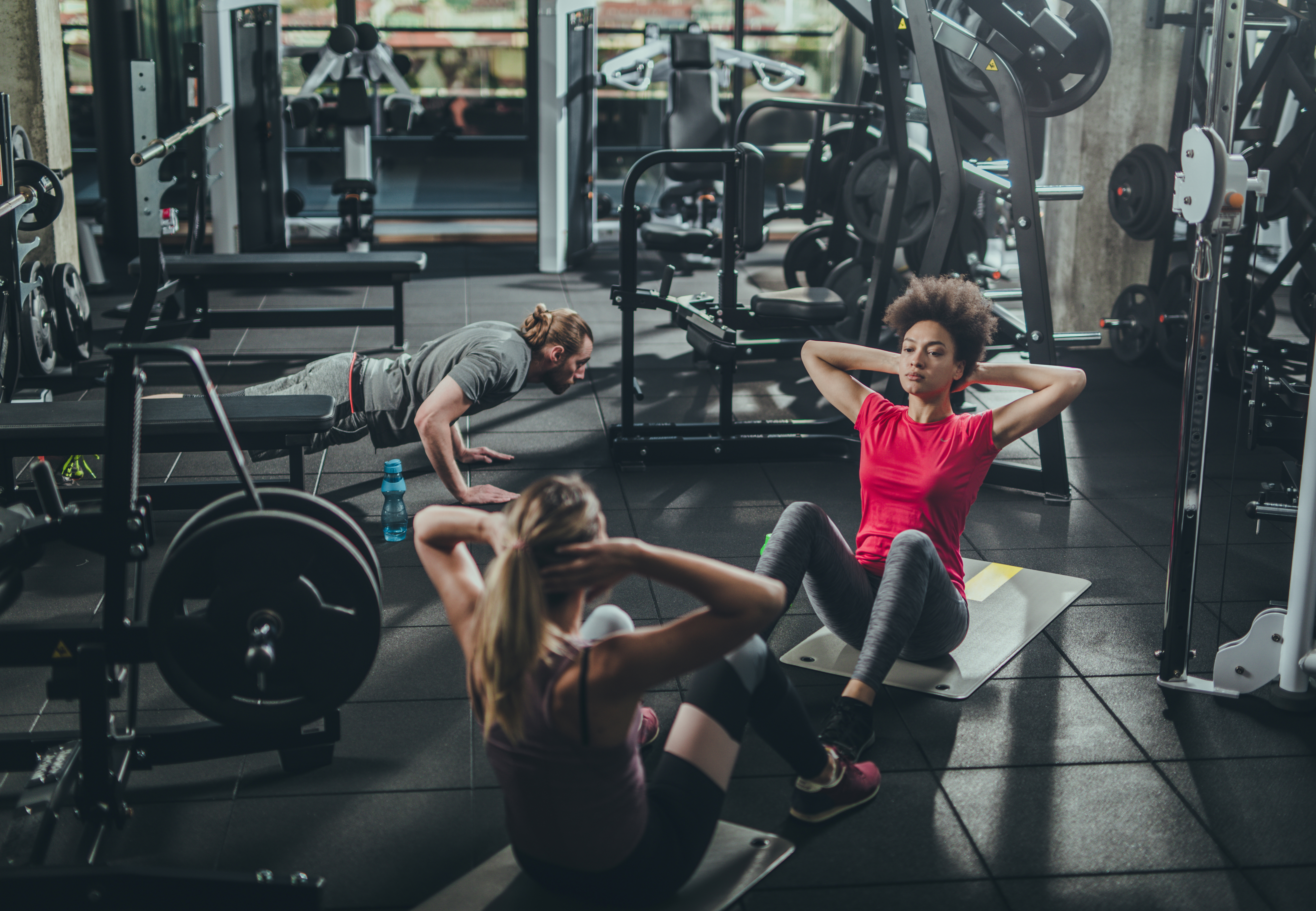 Group of athletic people having a sports training in a gym.