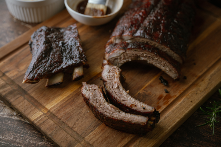 sliced barbeque spare ribs on wooden board